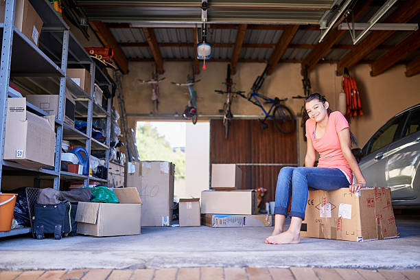 Portrait Of A Young Girl Sitting On A Box In A Garage